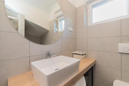 a bathroom with a white sink and a mirror at Villa Belveder in Pag