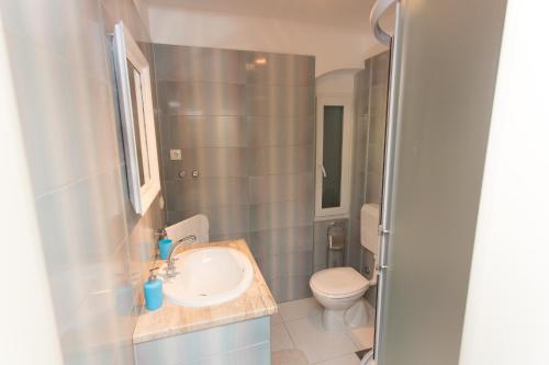 uma casa de banho com um lavatório e um WC em Apartments villa Mira em Kaštela