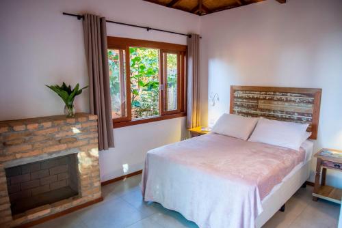 普拉亞做羅莎的住宿－Coração da Terra Praia do Rosa，一间卧室配有一张床和一个壁炉