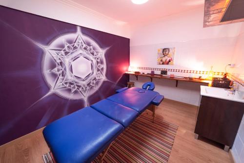 a blue couch in a room with a wall with a mirror at Surf Yoga Ericeira Guest House in Ericeira
