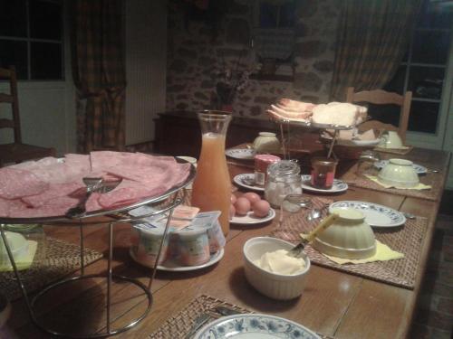 een houten tafel met borden met eten erop bij La Trainelière in Les Épesses
