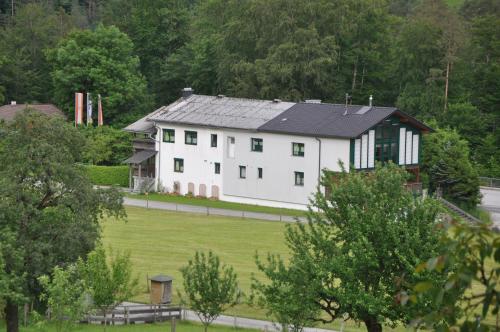 a large white house with a black roof at Mostheuriger Steyrdurchbruchalm in Leonstein