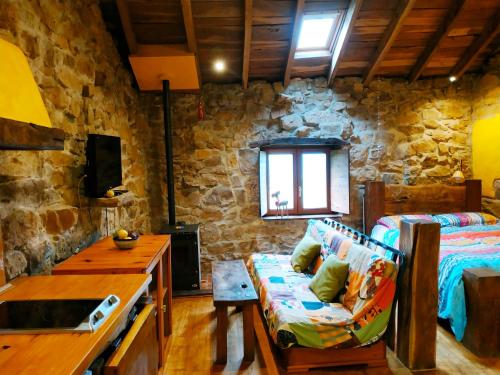 sala de estar con sofá y pared de piedra en Apartamento en Plena Naturaleza, en La Cavada