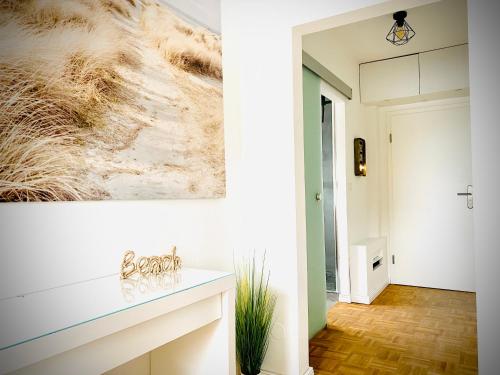 a living room with a painting on the wall at FeWo MEERESBRISE - Familie- Hunde - Strandnah - Garten-Seeblick - Sauna & Wellness in Sierksdorf