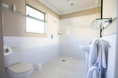 a white bathroom with a toilet and a sink at Murchison Motels in Murchison