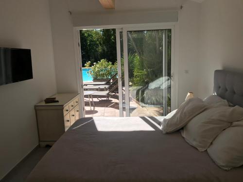 a bedroom with a bed and a view of a patio at Le Mas de la Dame in Saint-Tropez