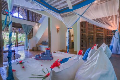 a room with a bed with red flowers on it at SeVi Boutique Hotel in Matemwe