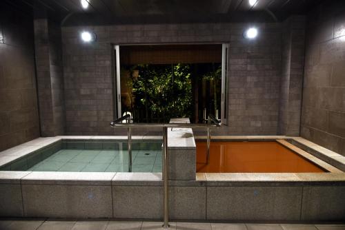 a swimming pool in a building at night at Arima Onsen Taketoritei Maruyama in Kobe