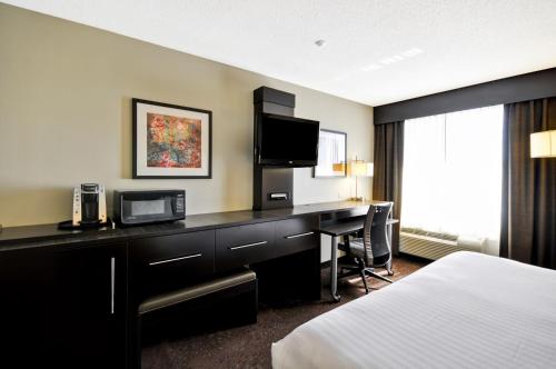 a hotel room with a desk and a bed at Holiday Inn Express Romulus / Detroit Airport by IHG in Romulus