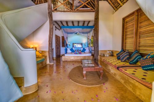 a room with a bed and a couch and a table at SeVi Boutique Hotel in Matemwe