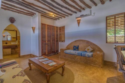 a living room with a couch and a table at SeVi Boutique Hotel in Matemwe