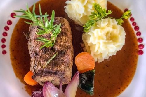 a plate of food with meat and vegetables on it at SeVi Boutique Hotel in Matemwe