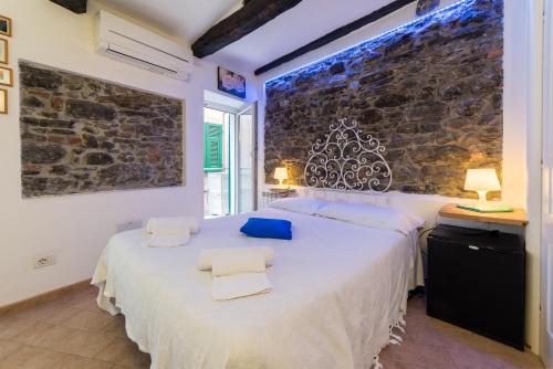 a bedroom with a large white bed with two chairs at Via Del Santo - FrancamariaDotCom in Vernazza
