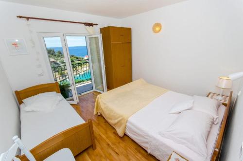 a bedroom with two beds and a balcony at Apartments Bosiljka - by the sea in Sevid