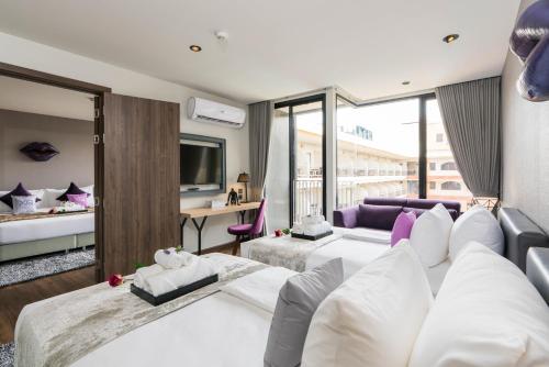 a hotel room with two beds and a tv at XQ Pattaya Hotel in Pattaya Central