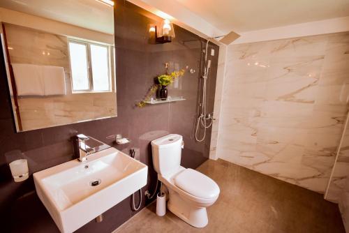 een badkamer met een wit toilet en een wastafel bij Top Terrace Cottage in Nuwara Eliya