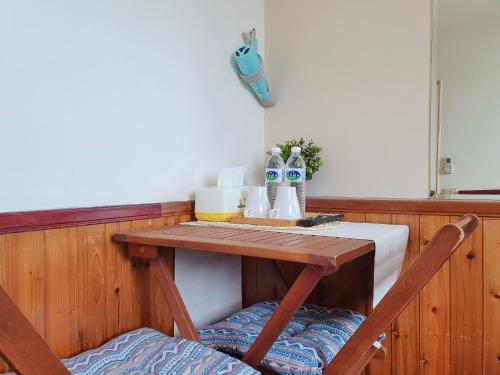 uma mesa de madeira com duas cadeiras num quarto em Kao Mama B&B em Jiufen