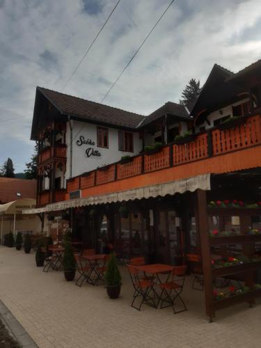 a restaurant with tables and chairs in front of a building at VILA SZOKE SOVATA in Sovata