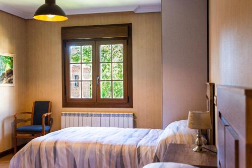 a bedroom with a bed and a window and a chair at Casa Almoravid in Daroca de Rioja