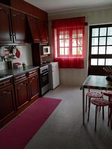 a kitchen with wooden cabinets and a table and a table and chairs at Quinta do Cabeço in Figueiró dos Vinhos