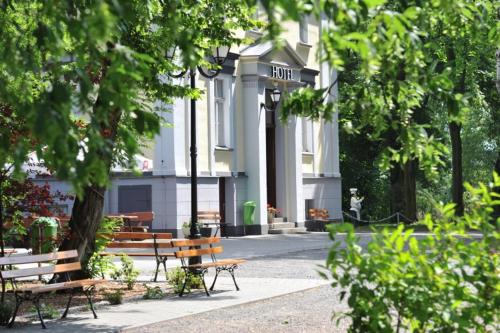 a group of benches in front of a building at Park Hotel Dobrodzień in Dobrodzień