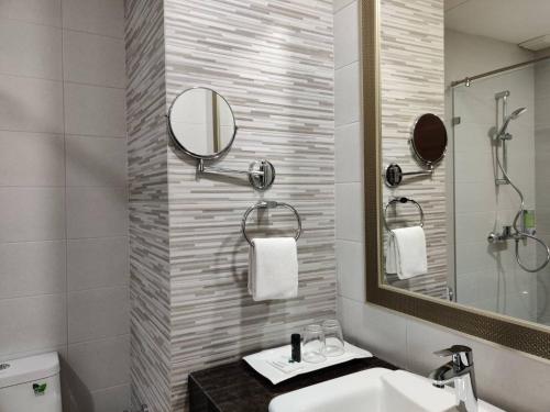 a bathroom with a sink and a mirror at Club Mahindra Mac Boutique Hotel in Bangkok