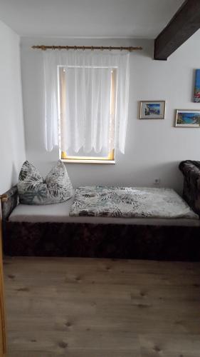 a bed sitting in a room with a window at Ferienwohnung Schlothauer 1 in Ruhla