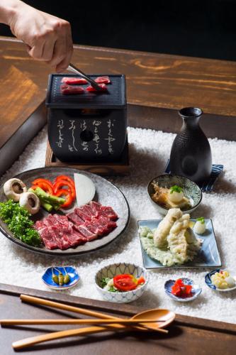 a table topped with a plate of food with chopsticks at Tomonoya Ryokan Geoje in Geoje 