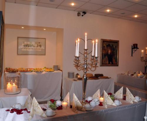 a dining room with two tables with white tablecloths at Residenz Royal in Sandhausen