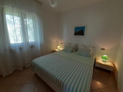 um quarto com uma cama, uma janela e 2 candeeiros em VILLA CASA SAGLIA em Malcesine