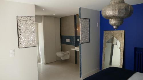 a bathroom with a toilet and a blue wall at La Rochelle et l'Aunis in Saint-Sauveur-dʼAunis