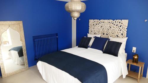 a blue bedroom with a bed and a mirror at La Rochelle et l'Aunis in Saint-Sauveur-dʼAunis