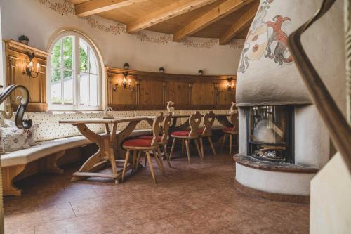 una camera con tavolo, sedie e camino di Bergrose Hideaway a Strobl