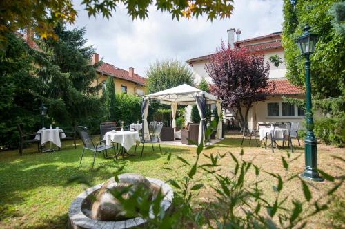 a garden with tables and chairs and a tent at Residenz Royal in Sandhausen
