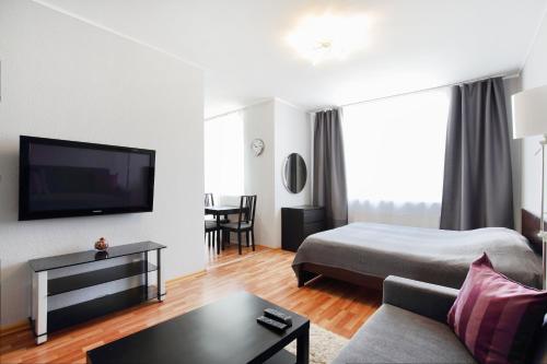 a living room filled with furniture and a tv at Apartments "Rooms" in Yekaterinburg