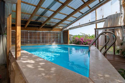 a swimming pool in a house with a glass ceiling at Rosh Pinat Noy in Rosh Pinna