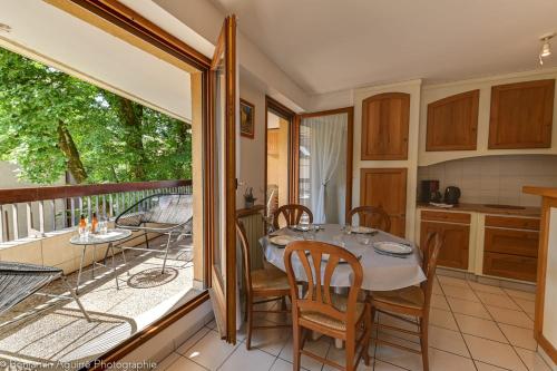 een keuken en eetkamer met een tafel en een balkon bij Le Vassé - Apartment 2 Bedrooms with terrace - pedestrian area in Annecy