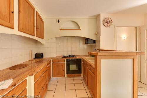 une cuisine avec des armoires en bois et un comptoir dans l'établissement Le Vassé - Apartment 2 Bedrooms with terrace - pedestrian area, à Annecy