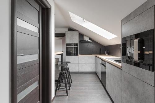 a kitchen with stainless steel appliances and black cabinets at The Attic in Zagreb