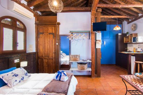 グラナダにあるLa Buhardilla de Mesones ,Vicent Suiteの青い壁のベッドルーム1室、ベッド1台が備わります。