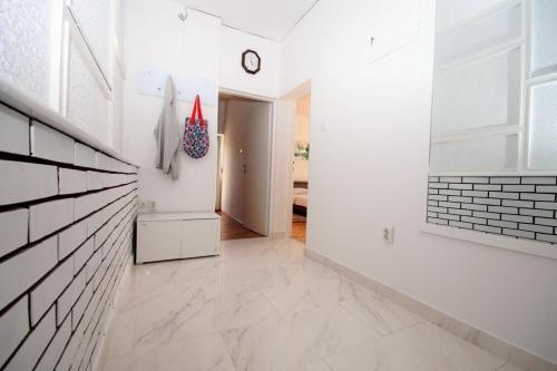 a hallway with white walls and a clock on the wall at Apartment Deni in Pula