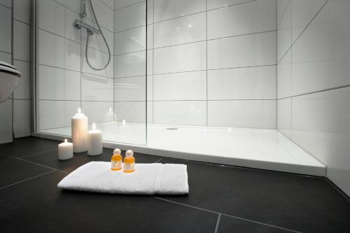 a bathroom with a shower and a towel and candles at Hotel zum Rössel in Kandel