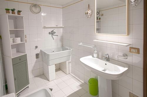 a white bathroom with a sink and a toilet at Casa Regina in Salò