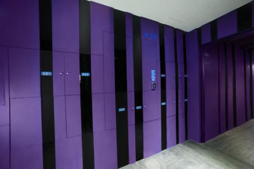 a room with purple walls and a row of lockers at Two Fukun Hotel in Jiaoxi
