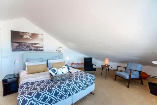 1 dormitorio con 1 cama azul y 1 silla en 't Spokeduin, en Zandvoort