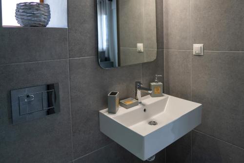 a bathroom with a white sink and a mirror at Sea View Apartment Grek Nea 3 in Nea Roda