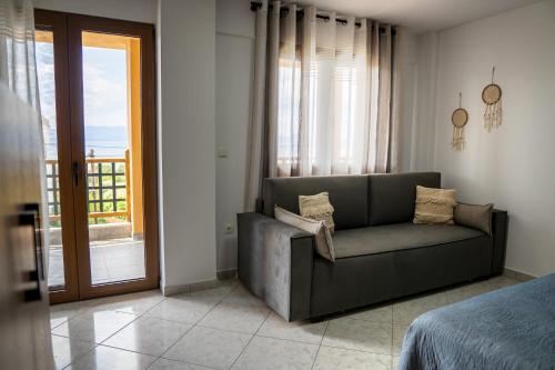 a living room with a couch in front of a window at Sea View Apartment Grek Nea 3 in Nea Roda