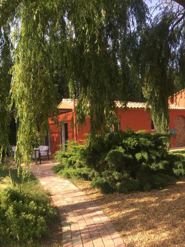 une passerelle devant un bâtiment rouge dans l'établissement Gite L olivier, à Baho