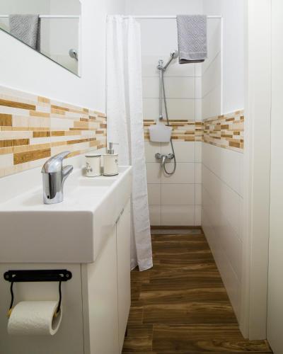 a white bathroom with a sink and a shower at Sobe Argo Izola in Izola