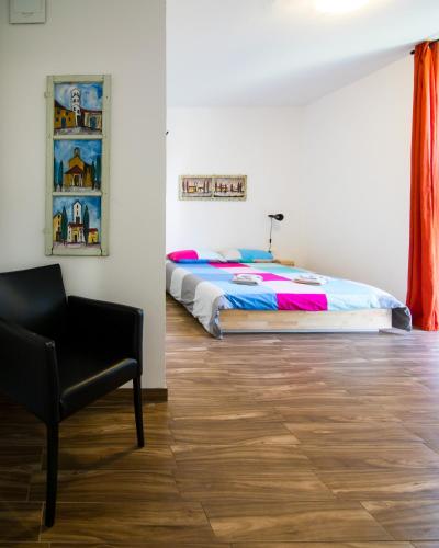a bedroom with a bed and a chair at Sobe Argo Izola in Izola